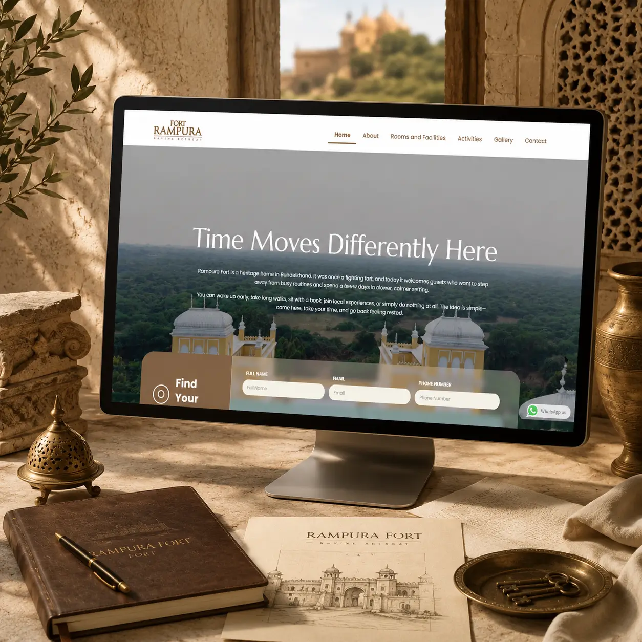 Luxury Fort Rampura heritage resort website displayed on a desktop monitor in a traditional Rajasthani-inspired setting.