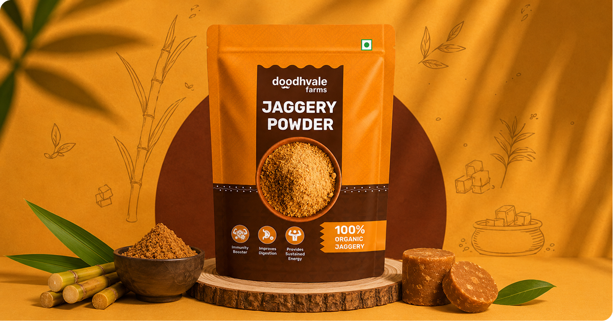 Doodhvale Farms Jaggery Powder pouch displayed on a wooden pedestal with sugarcane, jaggery pieces, and jaggery powder in a warm orange farm-inspired setting.